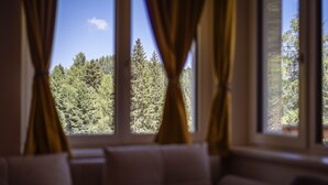 Um quarto com uma janela grande, cortinas e um sofá.