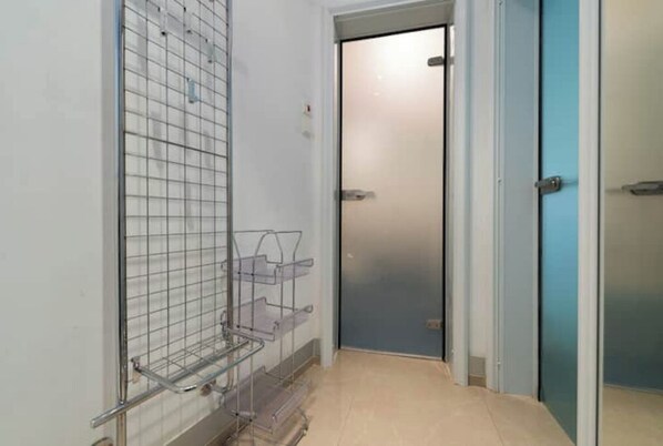 hallway with a storage shelf and secure door access.