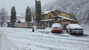 Une route enneigée avec un bâtiment sur lequel on peut voir une enseigne écrite dans une langue étrangère.