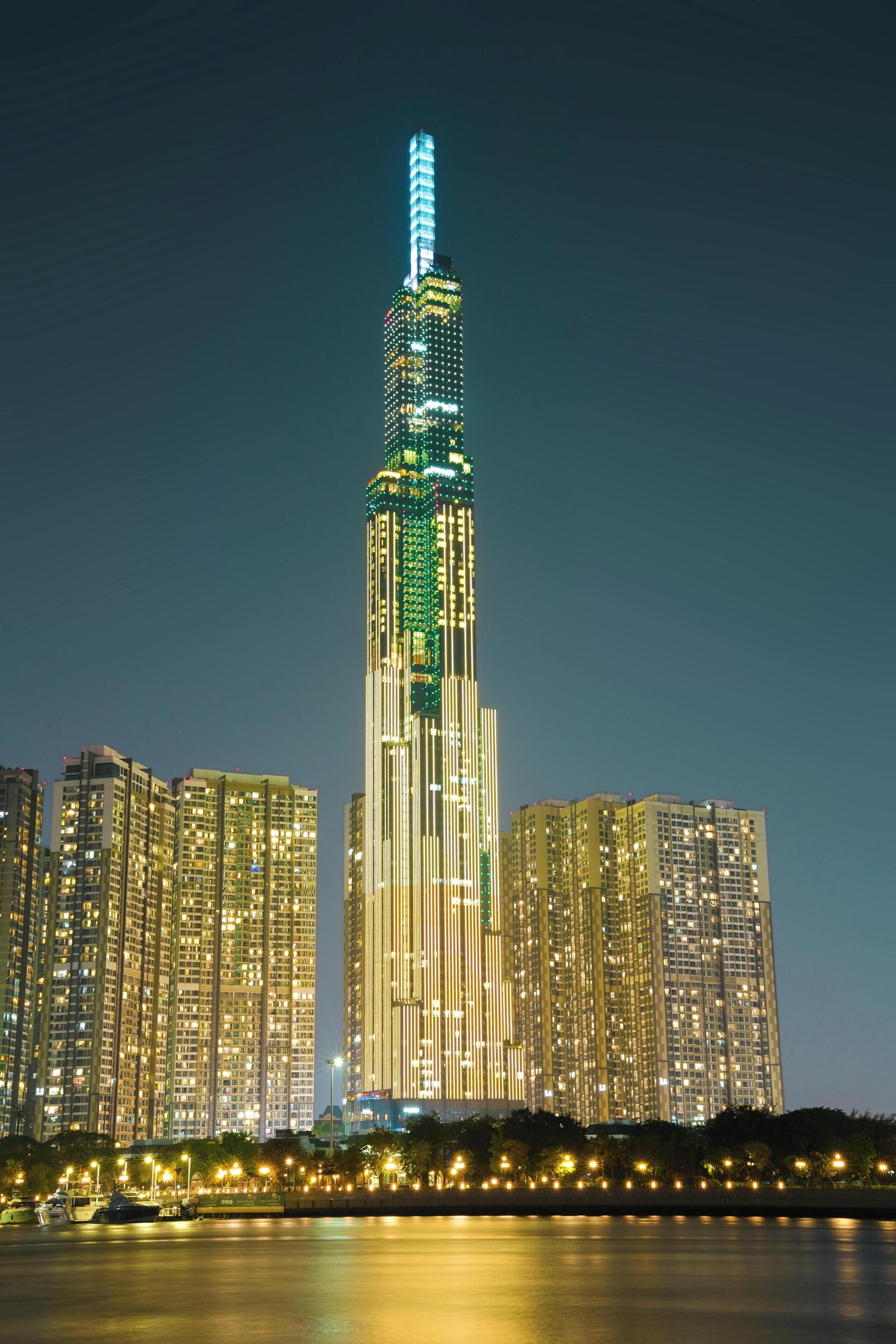 Un edificio de gran altura con un diseño vertical característico, rodeado de otros edificios altos.