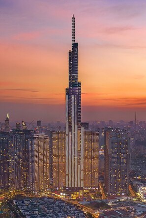 A high-rise building with a distinctive vertical design, surrounded by other tall buildings in a cityscape. - Vinhomes Central Park Premier Apartment (Ho Chi Minh City)
