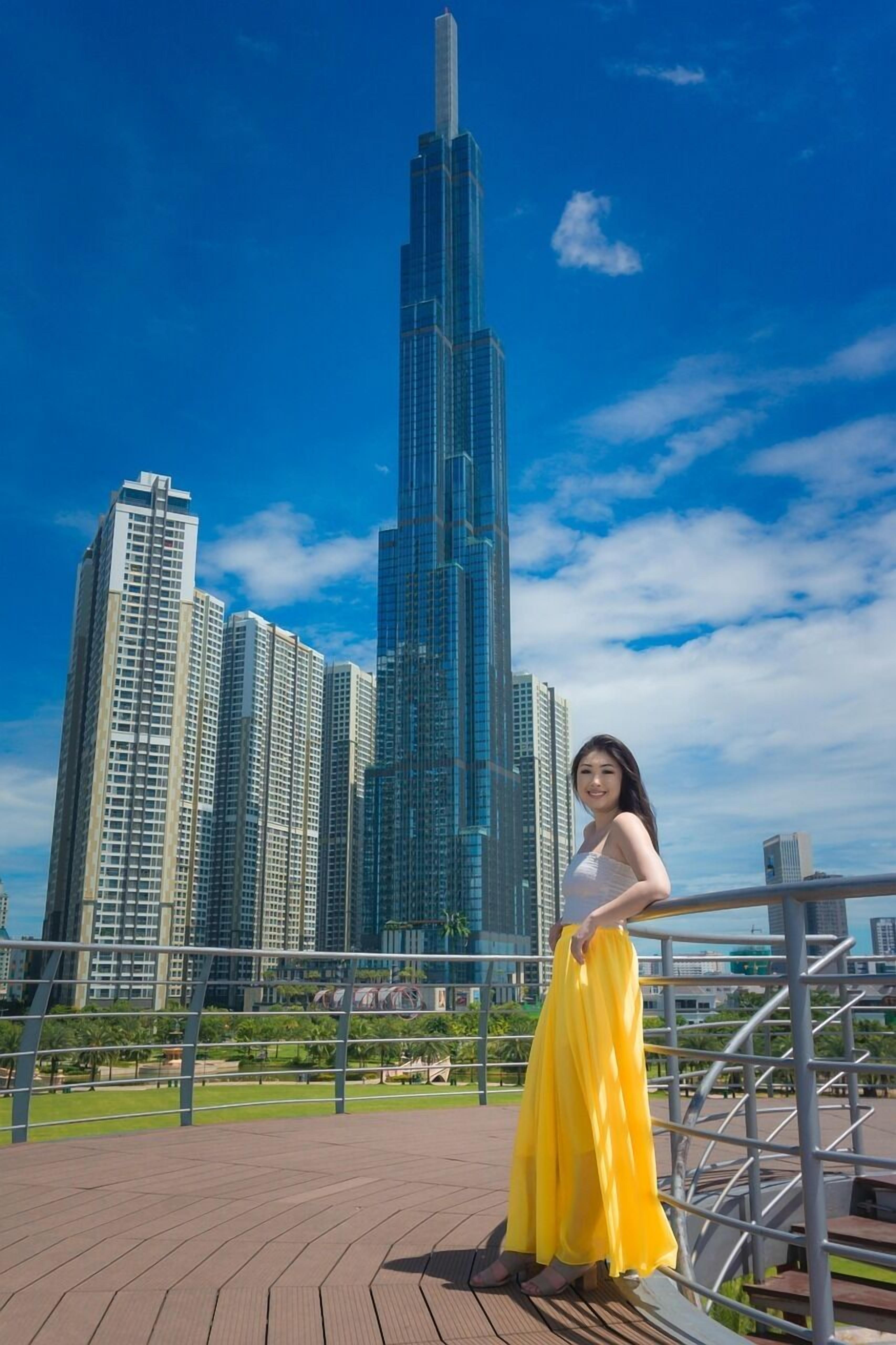 Eine Person steht auf einer Brücke, im Hintergrund eine Stadtansicht.