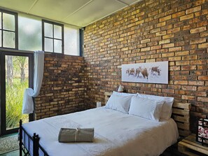 Cozy retreat with a brick-patterned wall, large window, and a view of lush greenery.