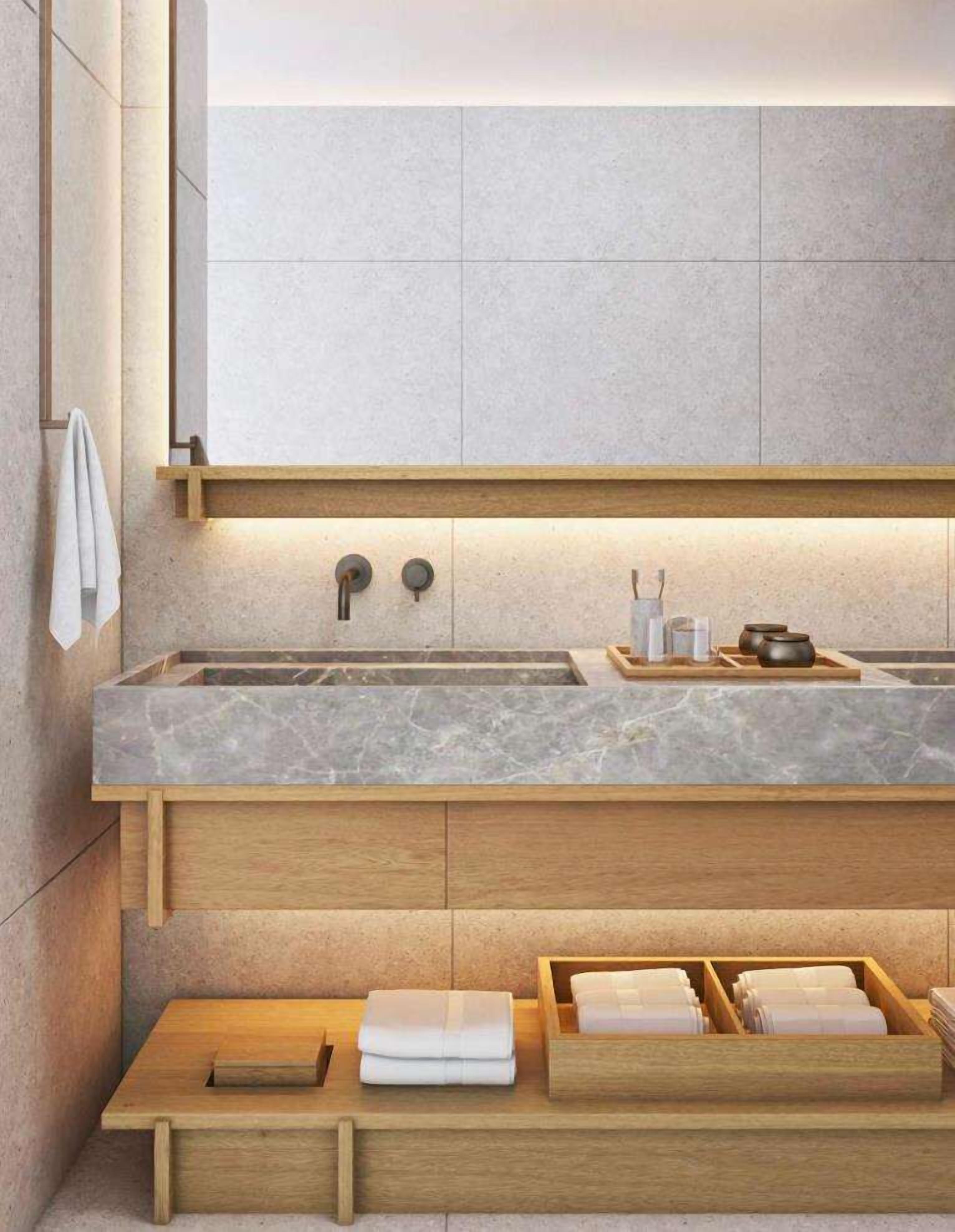 A modern bathroom with a marble sink, wooden vanity, and a towel rack.