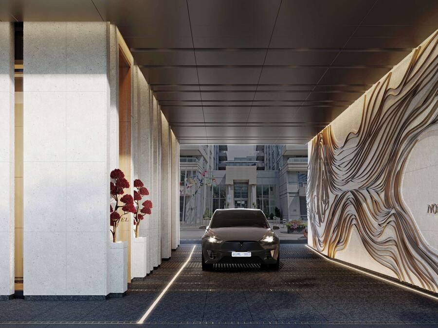 Entrada moderna de un hotel con un coche elegante en la entrada.