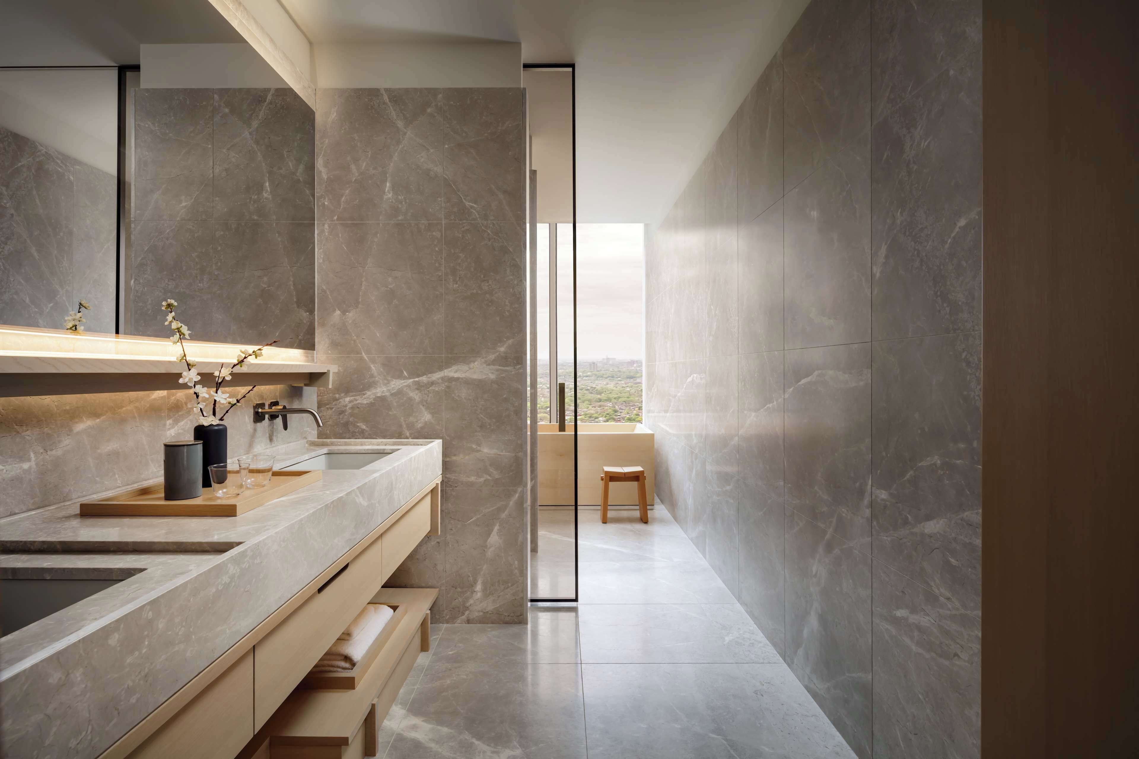 Une salle de bain moderne dotée d’un grand miroir, de deux lavabos et offrant une vue sur l’extérieur.