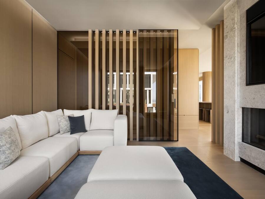A modern living room with a sectional sofa, a fireplace, and a sliding glass door leading to an outdoor area.