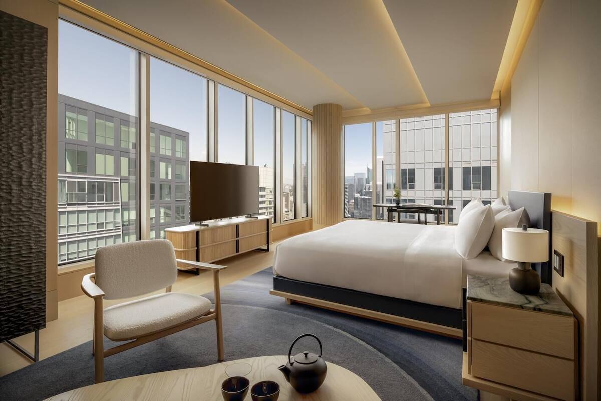 Et moderne hotelværelse med en stor seng, et fjernsyn, et skrivebord og en stol.