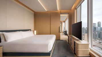 Une chambre d’hôtel moderne avec un grand lit, une télévision et une vue sur la ville.