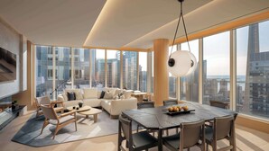 Una sala de estar moderna con un amplio comedor, asientos cómodos y vistas a la ciudad a través de grandes ventanales.