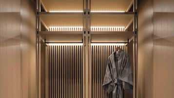 A modern, minimalist walk-in closet with built-in drawers and a shoe rack.