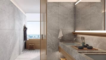 A modern bathroom with a large mirror, a bathtub, and a wooden bench.