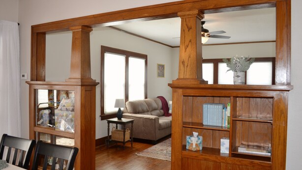 A living room with a wooden bookshelf, a sofa, and a dining table. - Wild Rose Cottage



Save
 (De Smet)