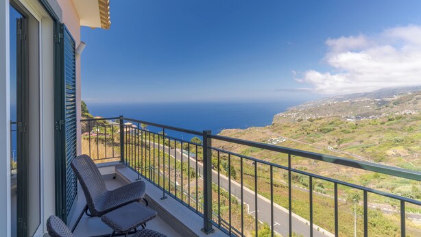 A balcony with a view of the sea and a road leading to a village. - Villa Quinta Grande (Camara de Lobos)