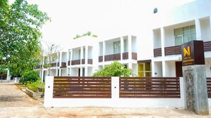 A modern hotel with a white facade, multiple balconies, and a prominent 'N' logo on the entrance. - Ananthara Resort (Anuradhapura)