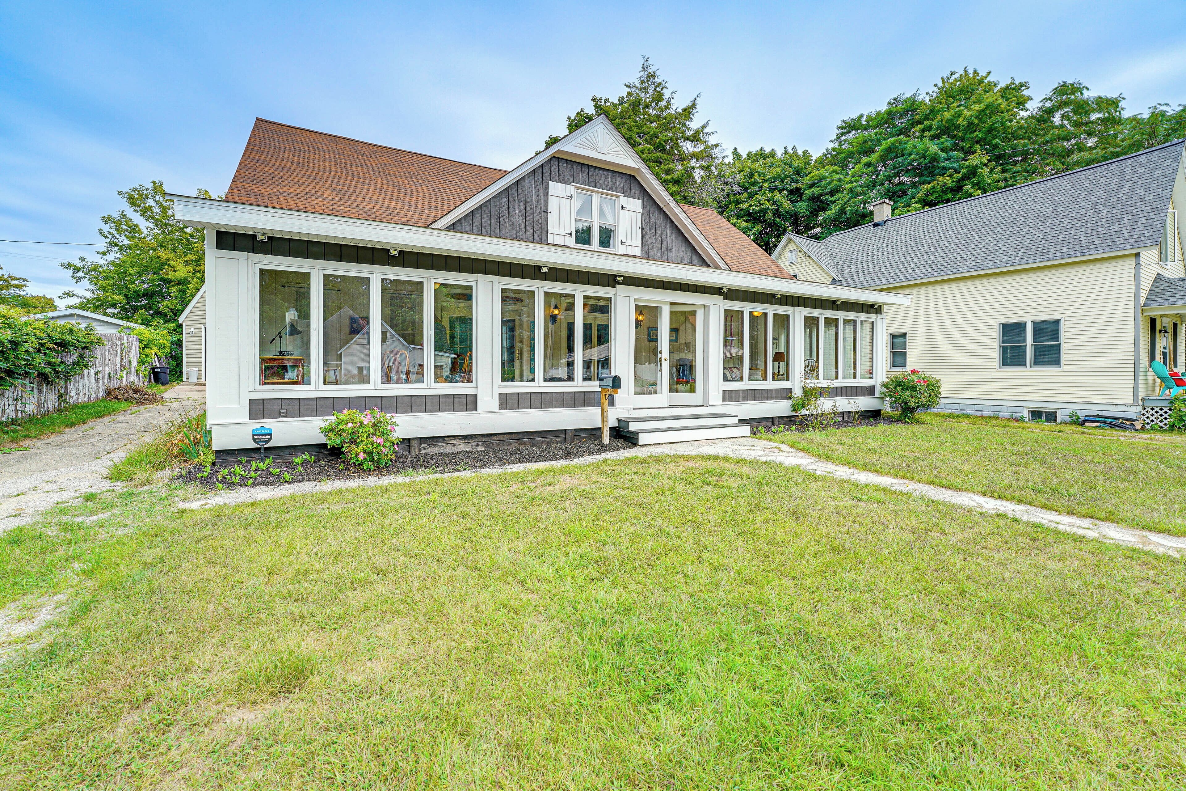 A two-story house with a large front porch, a covered entryway, and a small front yard.