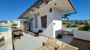 Eine moderne Außenpatio mit Pool, Sitzbereich und Blick auf die umliegenden Gebäude.