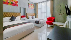 A modern hotel room with two beds, a red chair, a small table, and artwork on the walls. - The Batik Bed and Coffee (Bandung)