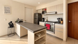 A modern kitchen with a central island, stainless steel appliances, and a minimalist design. - Maravilia 3 bedrooms/2 bathrooms/2 (Guadalajara)