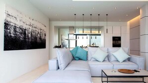 Ein modernes Wohnzimmer mit einem hellgrauen Sofa, einem Couchtisch und einem großen abstrakten Gemälde an der Wand.