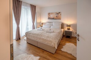 A modern bedroom with a large bed, two bedside tables with lamps, a fluffy rug, and a painting on the wall. - Fantastic apartment - Terrace- Hanging chair- Highspeed WiFi (Viersen)