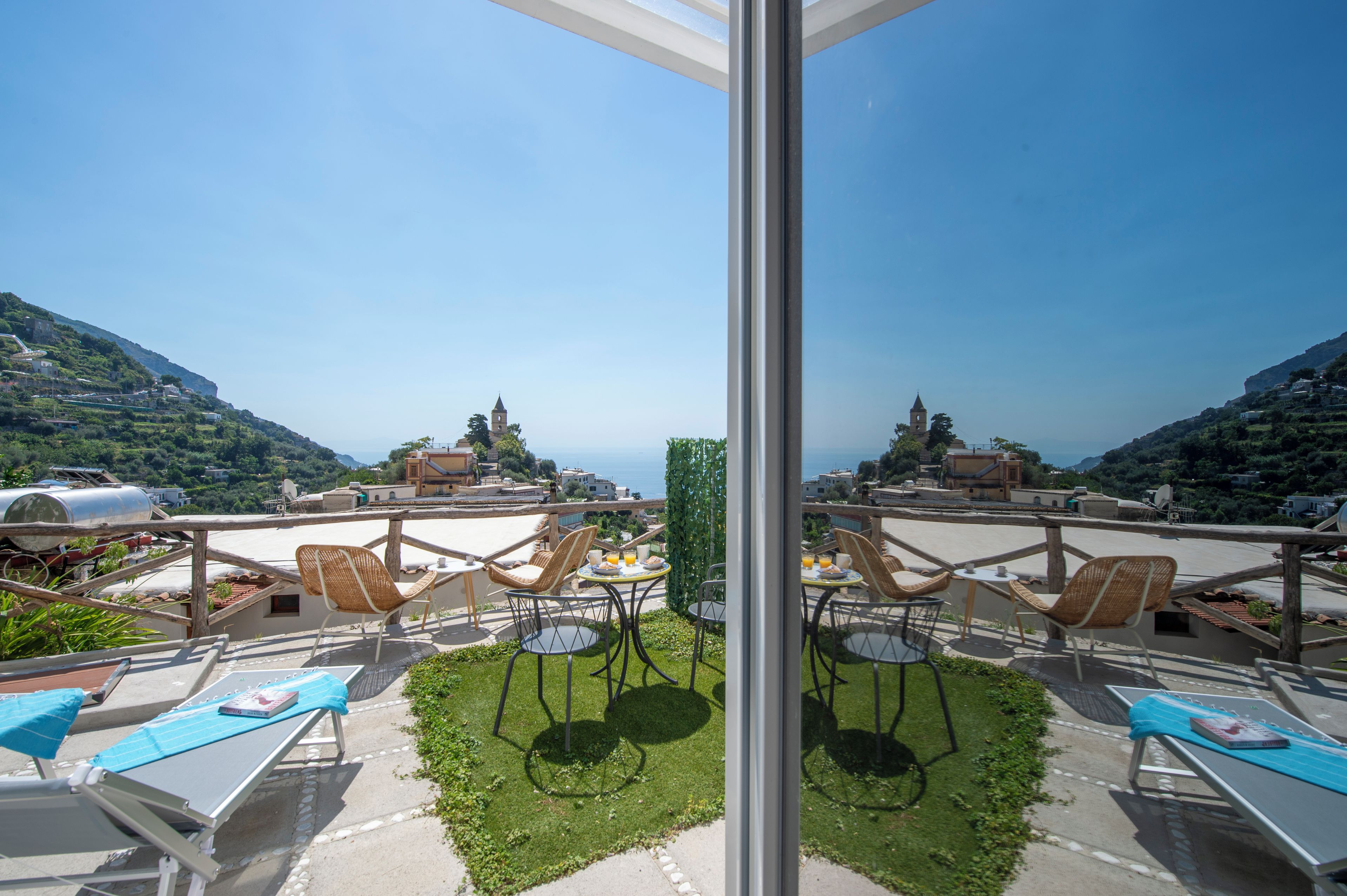 Eine Terrasse mit Sitzgelegenheit und Meerblick.