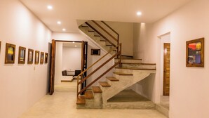 Un escalier moderne avec des marches en bois et des rampes en métal, menant à l’étage supérieur.