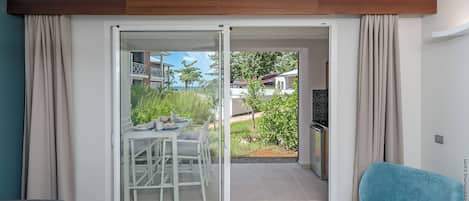 A modern hotel room with a sliding glass door leading to an outdoor patio.
