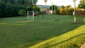 A well-maintained backyard with a grassy lawn, a soccer goal, and a wooden fence. - Marisol, spacious and comfortable farm in Araçoiaba da Serra  (Araçoiaba da Serra)