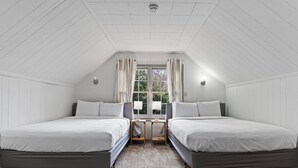 Ein Zimmer mit zwei Betten, einem Vorhangfenster und Blick auf Grünflächen.