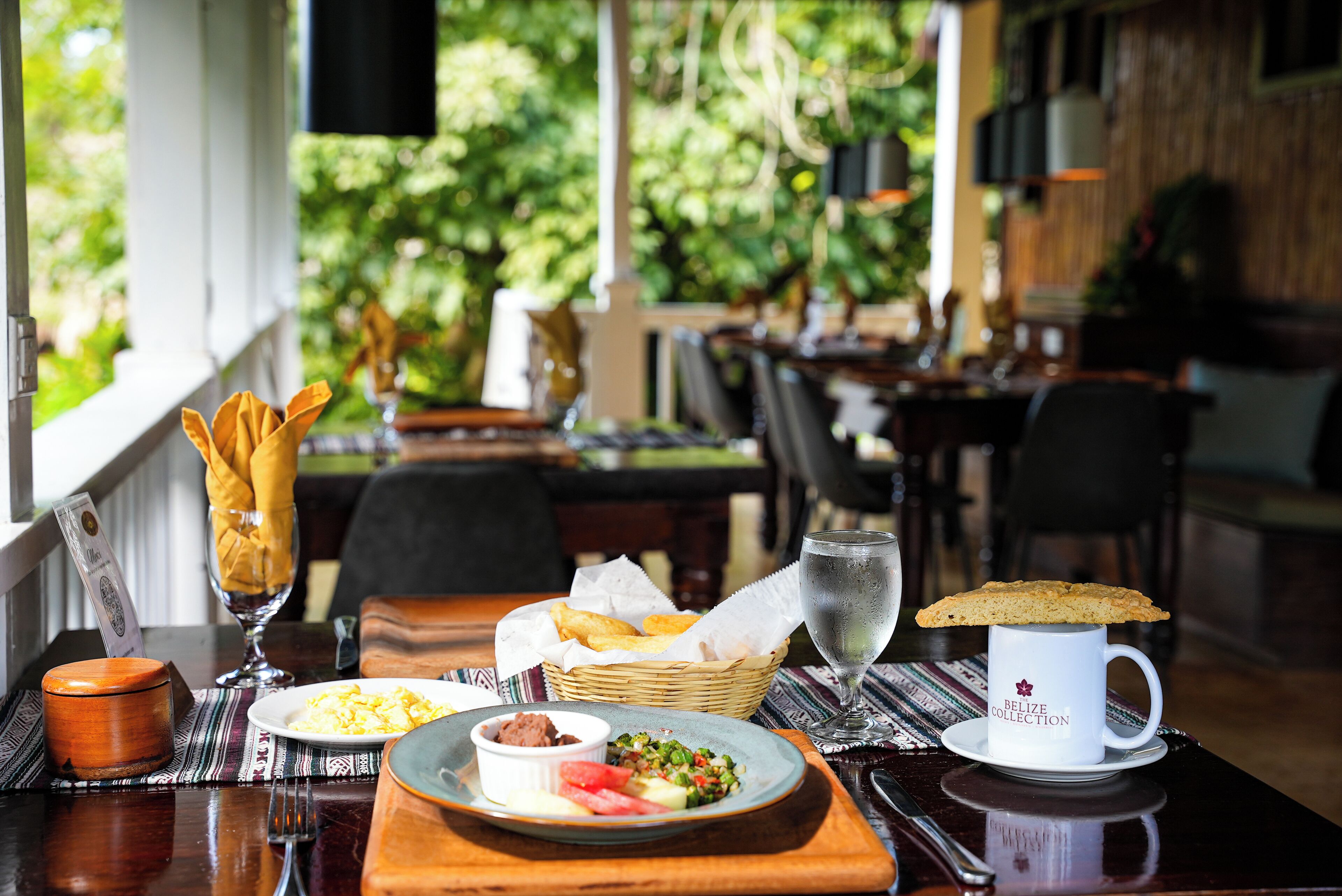 A table set with breakfast items including eggs, toast, and a mug labeled "Belize Collection".