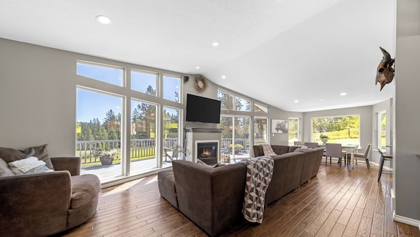 Amplia sala de estar con chimenea, ventanas grandes y vistas al exterior.
