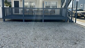 Een meerhoog gebouw met een balkon en een trap, en een bordje met de tekst 'Parkeer niet op looppad'.