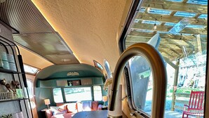 Una cocina con un lavamanos de acero inoxidable, encimera de madera y ventana con vistas al exterior.