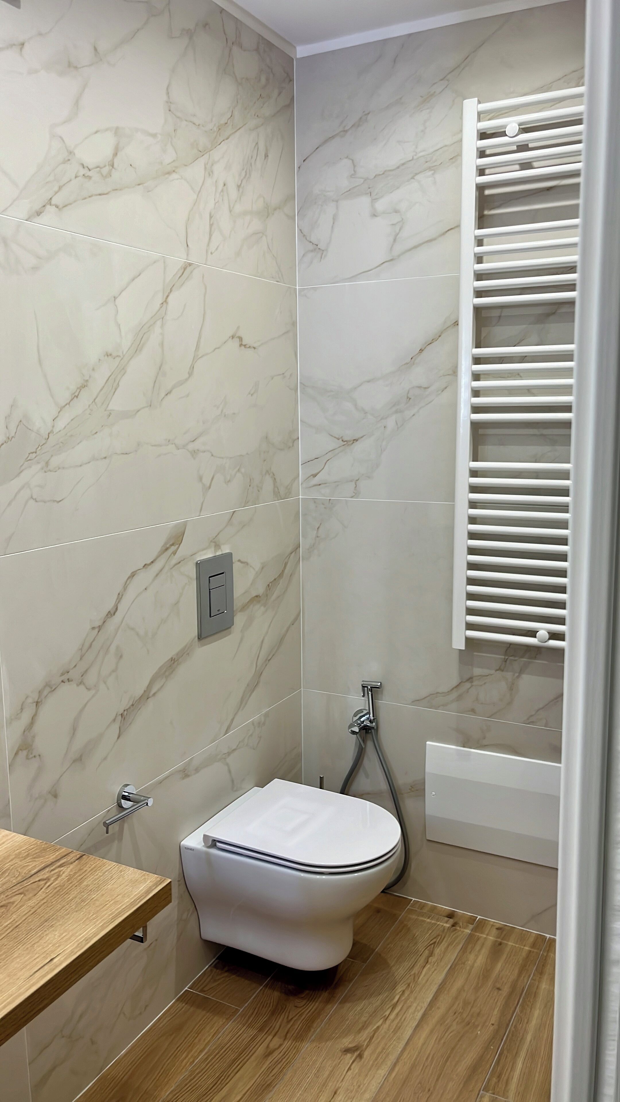 Une salle de bain avec des toilettes, une douche et un meuble-lavabo en bois.