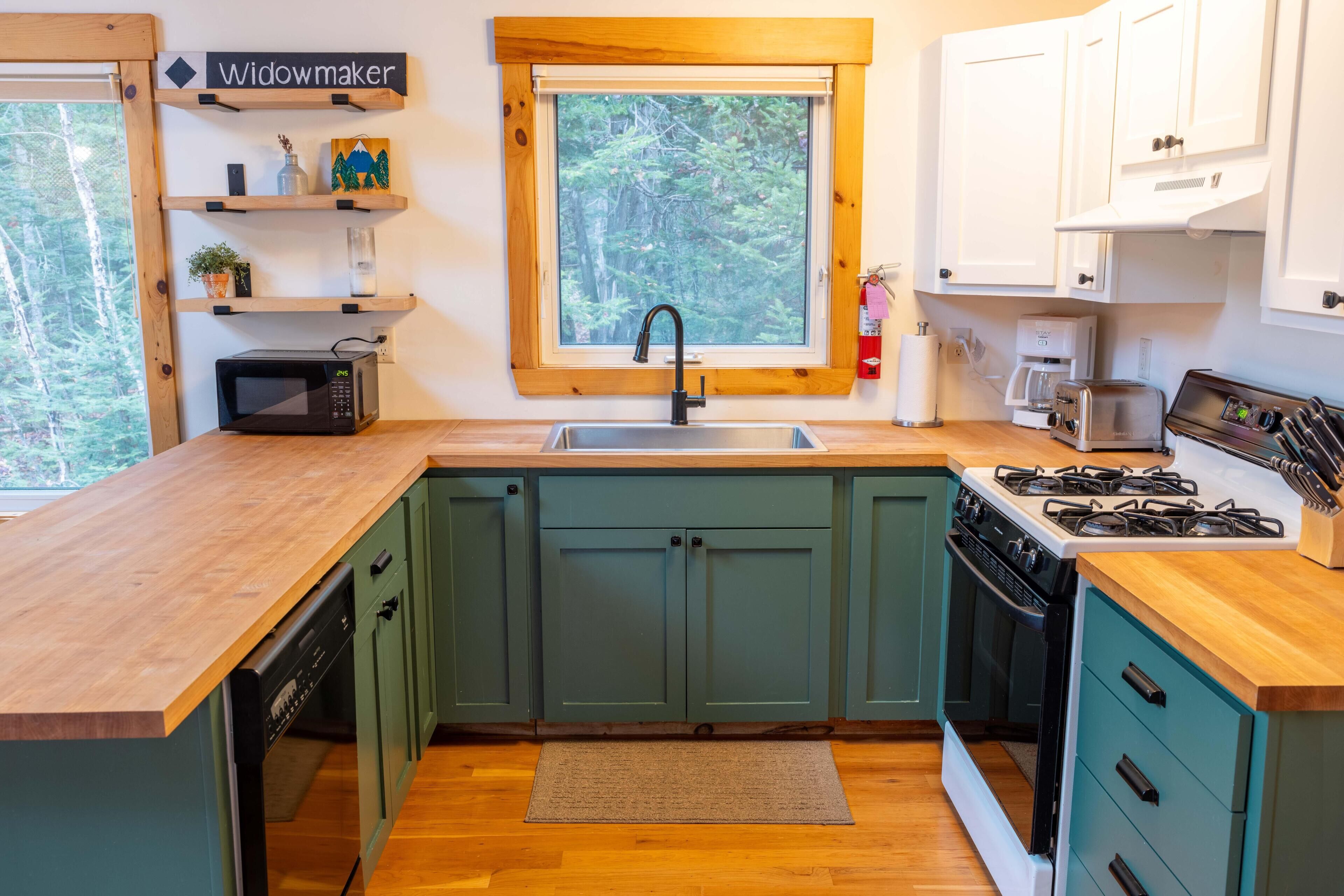 A compact kitchen with a microwave, sink, and stove.
