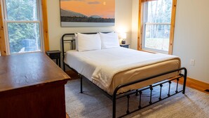 A bedroom with a bed, a nightstand, a lamp, and a painting on the wall. - Sugarloaf Mountain Fir Avenue C3004 (Carrabassett Valley)