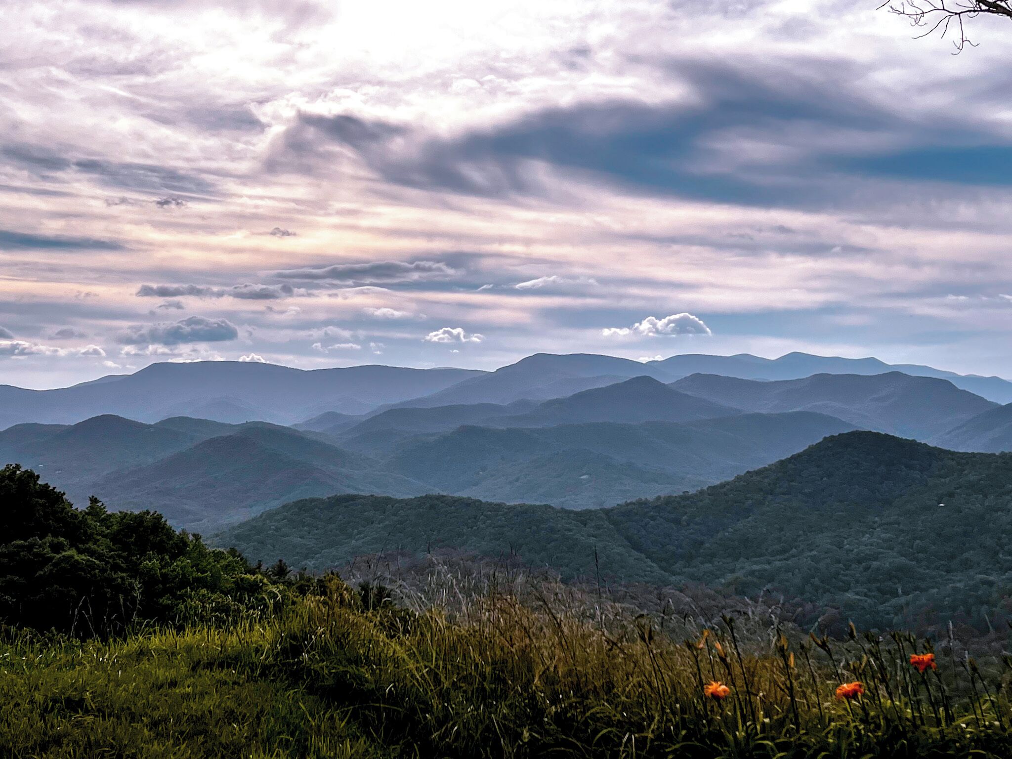 A mountainous landscape with rolling hills and a cloudy sky.