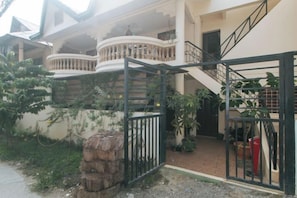 A residential building with a gated entrance, a staircase, and a balcony. - RedDoorz @ The Central Inn Boracay Island (Boracay Island)