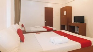 A hotel room with two beds, a TV, a desk, and a wardrobe. - RedDoorz @ The Central Inn Boracay Island (Boracay Island)