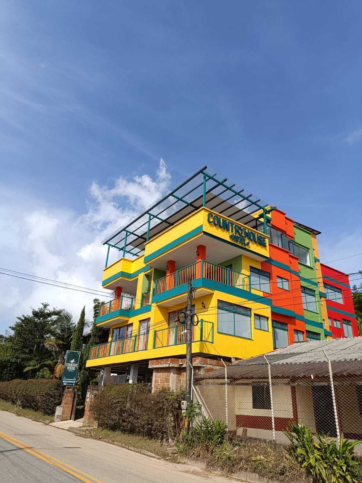 A multi-story building with a colorful facade, balconies, and a sign indicating it is a country house.