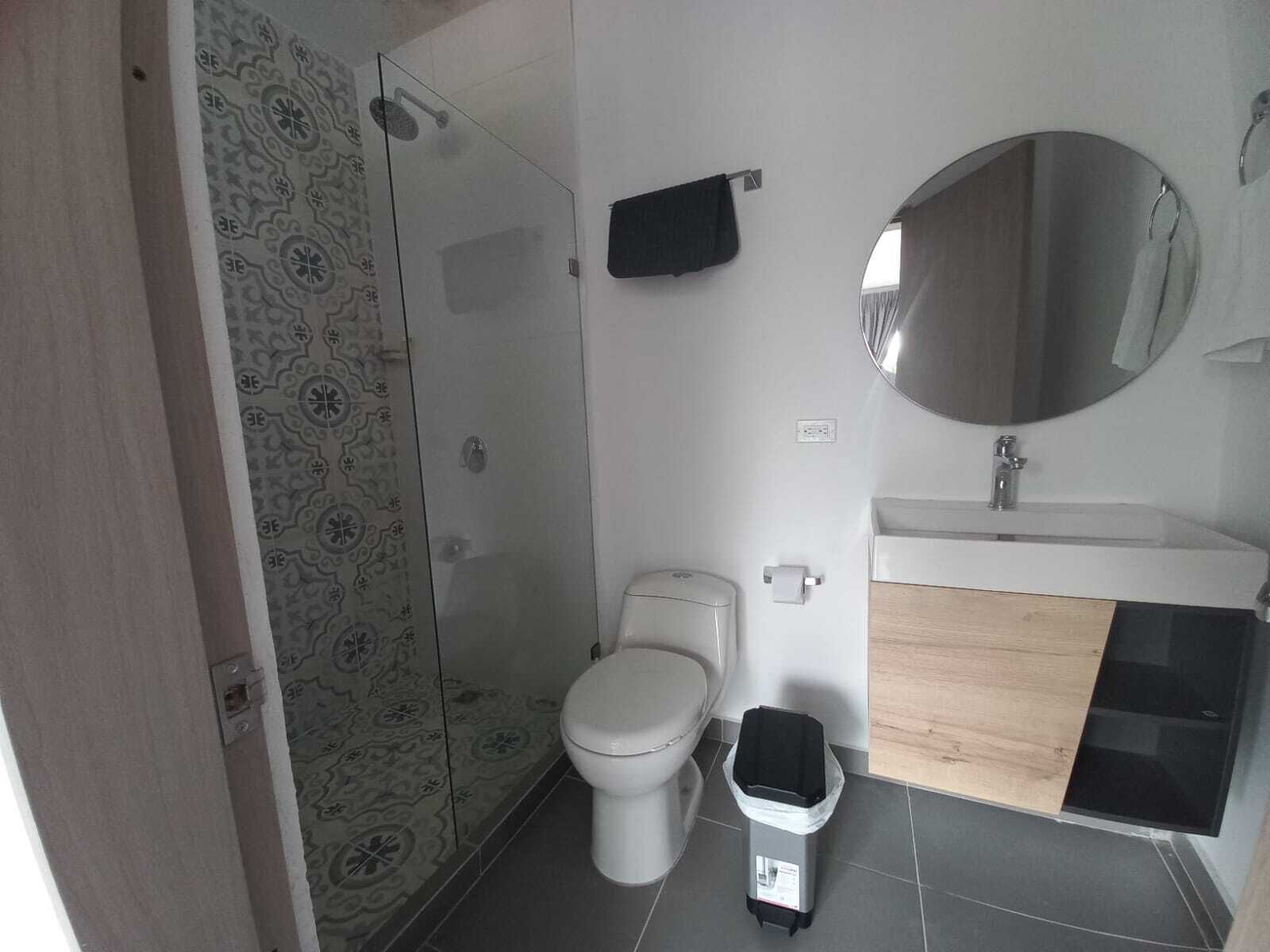 A modern bathroom with a toilet, sink, and shower.
