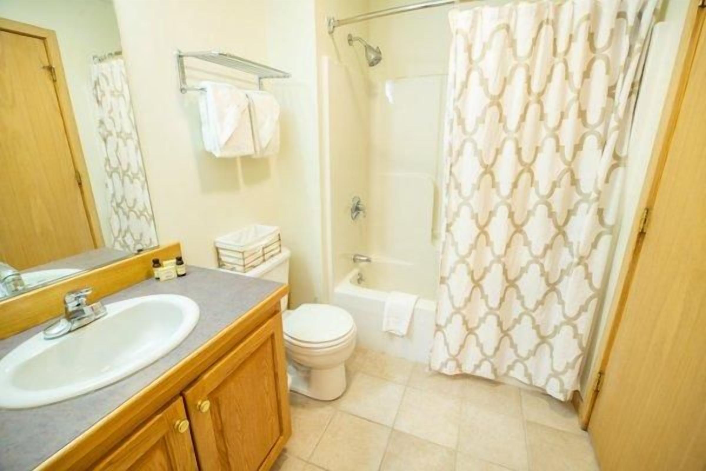 A bathroom with a sink, toilet, and shower.
