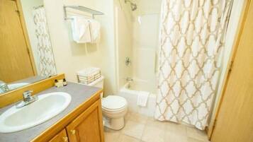 A bathroom with a sink, toilet, and shower.