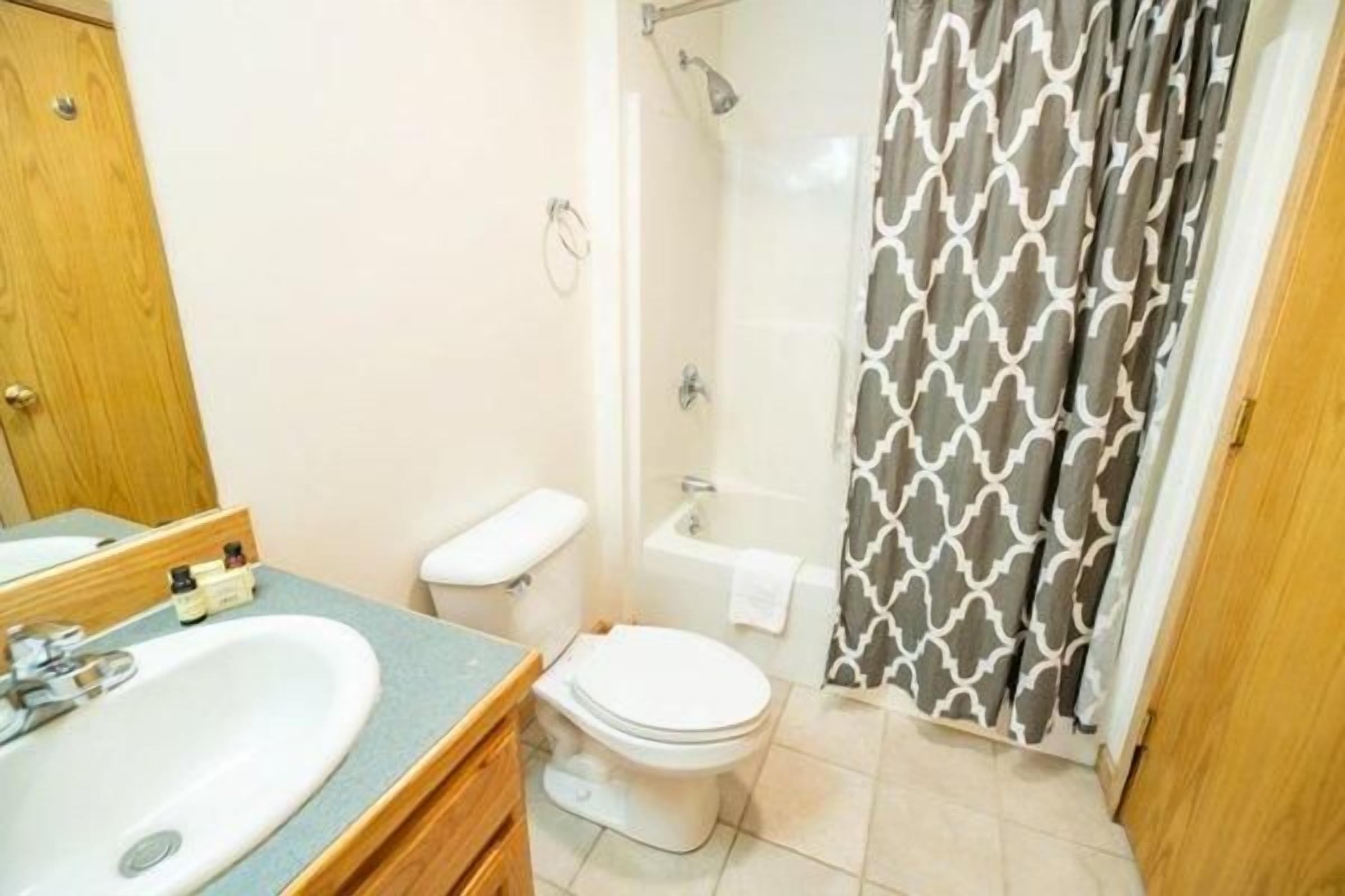 A bathroom with a sink, toilet, and shower.
