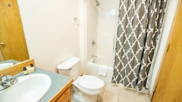 A bathroom with a sink, toilet, and shower.