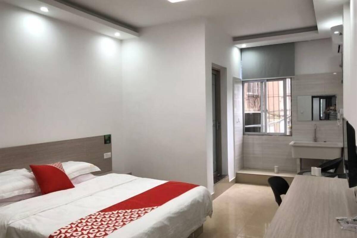 A hotel room with a bed, a desk, and a bathroom.