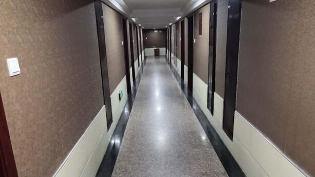 A long, narrow hallway with a polished floor and dark walls, leading to a door at the end. - Shangrao Raowei Hotel (Shangrao)