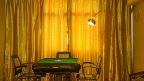 Una habitación con una mesa de billar verde, dos sillas y una lámpara.