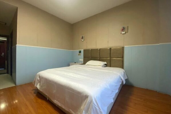 A bedroom with a single bed, wooden flooring, and a headboard. - Shangrao Raowei Hotel (Shangrao)